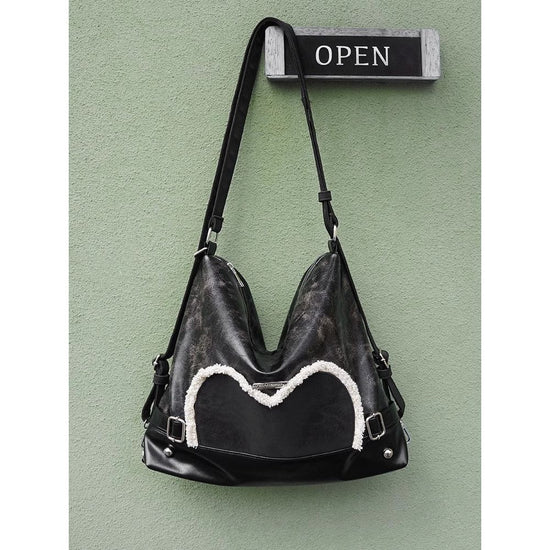 Stylish black tote backpack with heart embellishment - can be worn on one shoulder or as a backpack