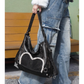 Stylish black tote backpack with heart embellishment - can be worn on one shoulder or as a backpack